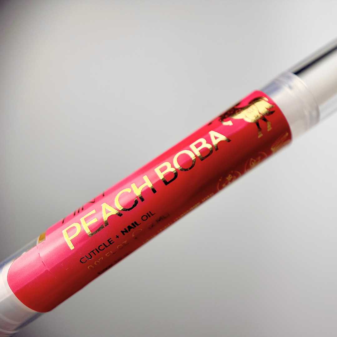Peach Boba cuticle nail oil twist pen with red label on a white background