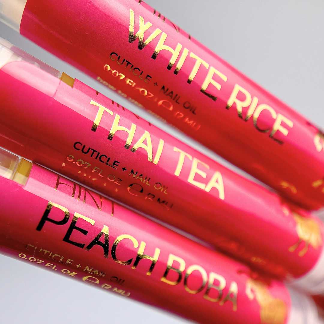 Three red tubes of cuticle oil with 'White Rice', 'Thai Tea', and 'Peach Boba' text on a white background.