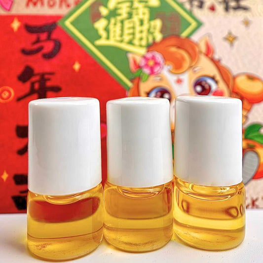 Three 1 milliliter bottles of cuticle oil on a colorful background with cartoon characters representing the Year of the Horse