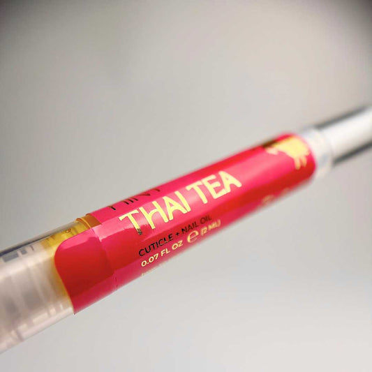 Cuticle oil twist pen with 'THAI TEA' text on a light grey background